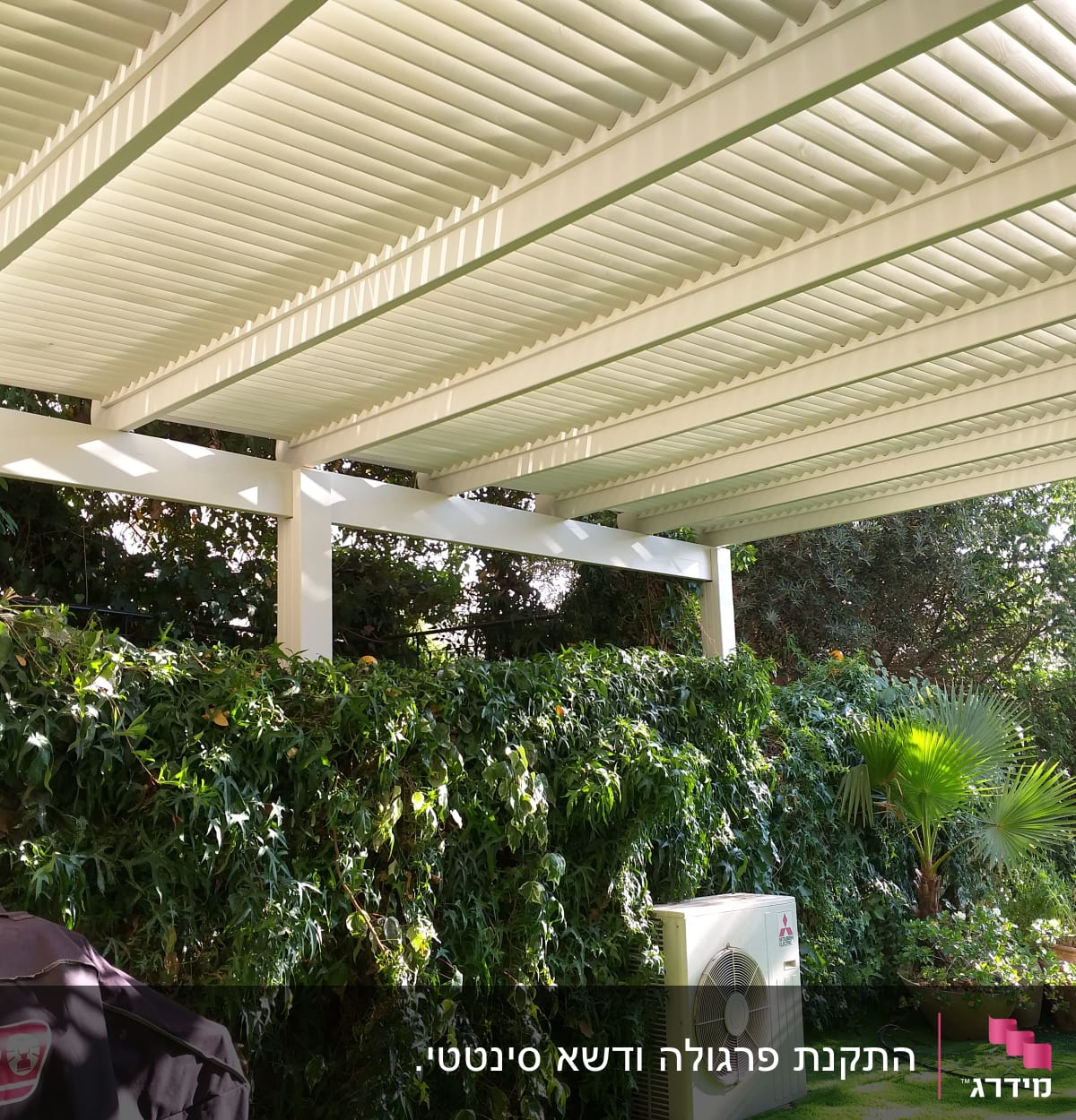 פרגולה לבנה מעל גינה עם צמחייה ירוקה